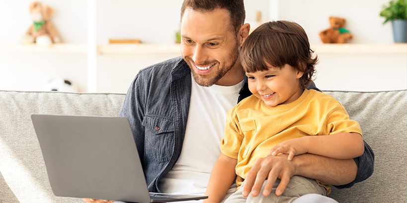 dad with todler doing speech therapy online
