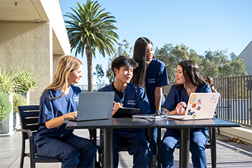 nursing studnet sitting at a table talking