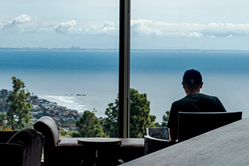 Pepperdine student working in Payson Library facing the ocean