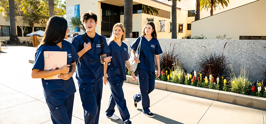 studnet walking in scrubs on malibu campus