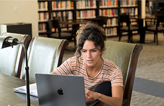 studnets on laptop in library